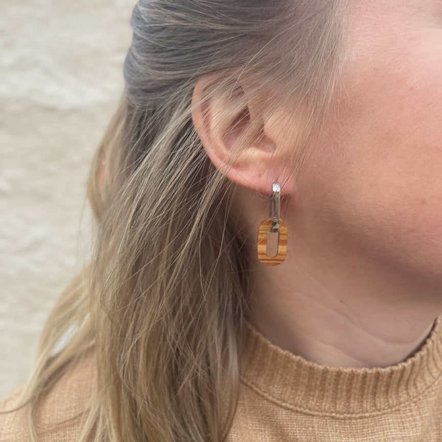 Boucles d'oreilles créoles ovales femme argentées en bois précieux et acier inoxydable. Fabrication artisanale en France par une ébéniste