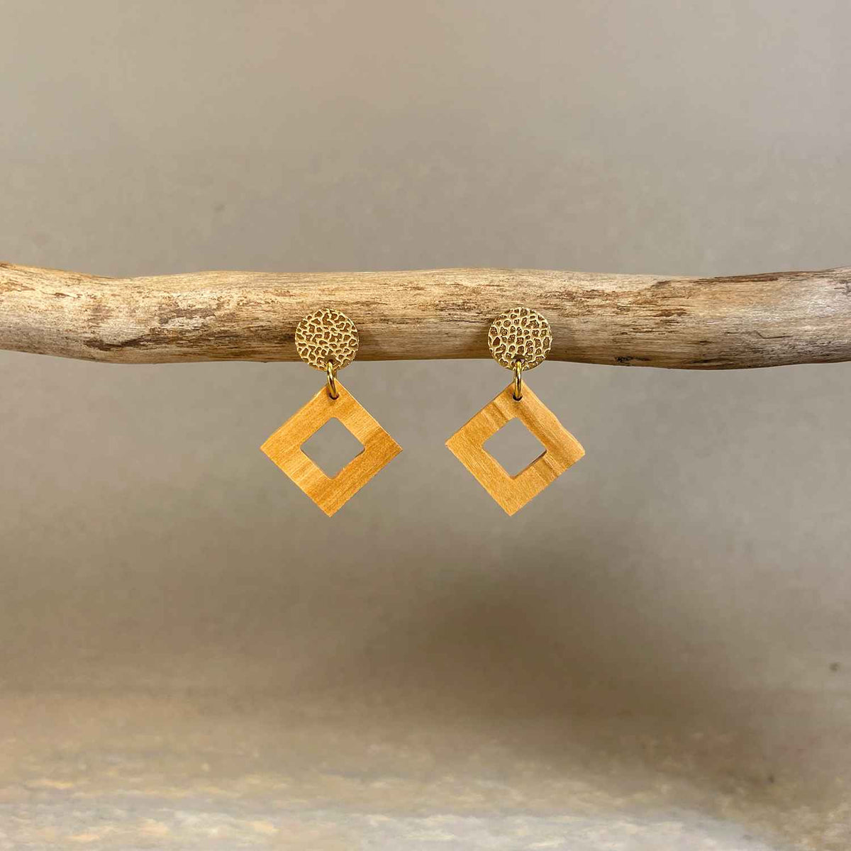 boucles d'oreilles clous carrés femme en bois d'olivier et acier doré, accrochées à une branche, fabrication artisanale française, racines artisanat