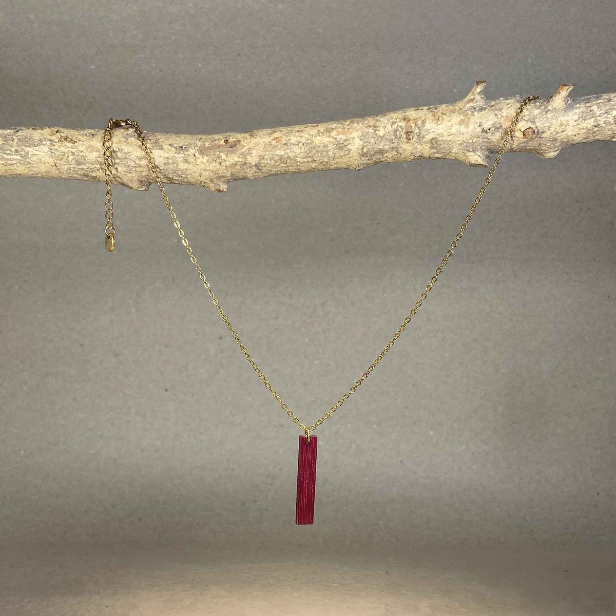 collier pendentif barre femme en bois d'amarante et acier doré, suspendu à une branche, fabrication artisanale française, racines artisanat