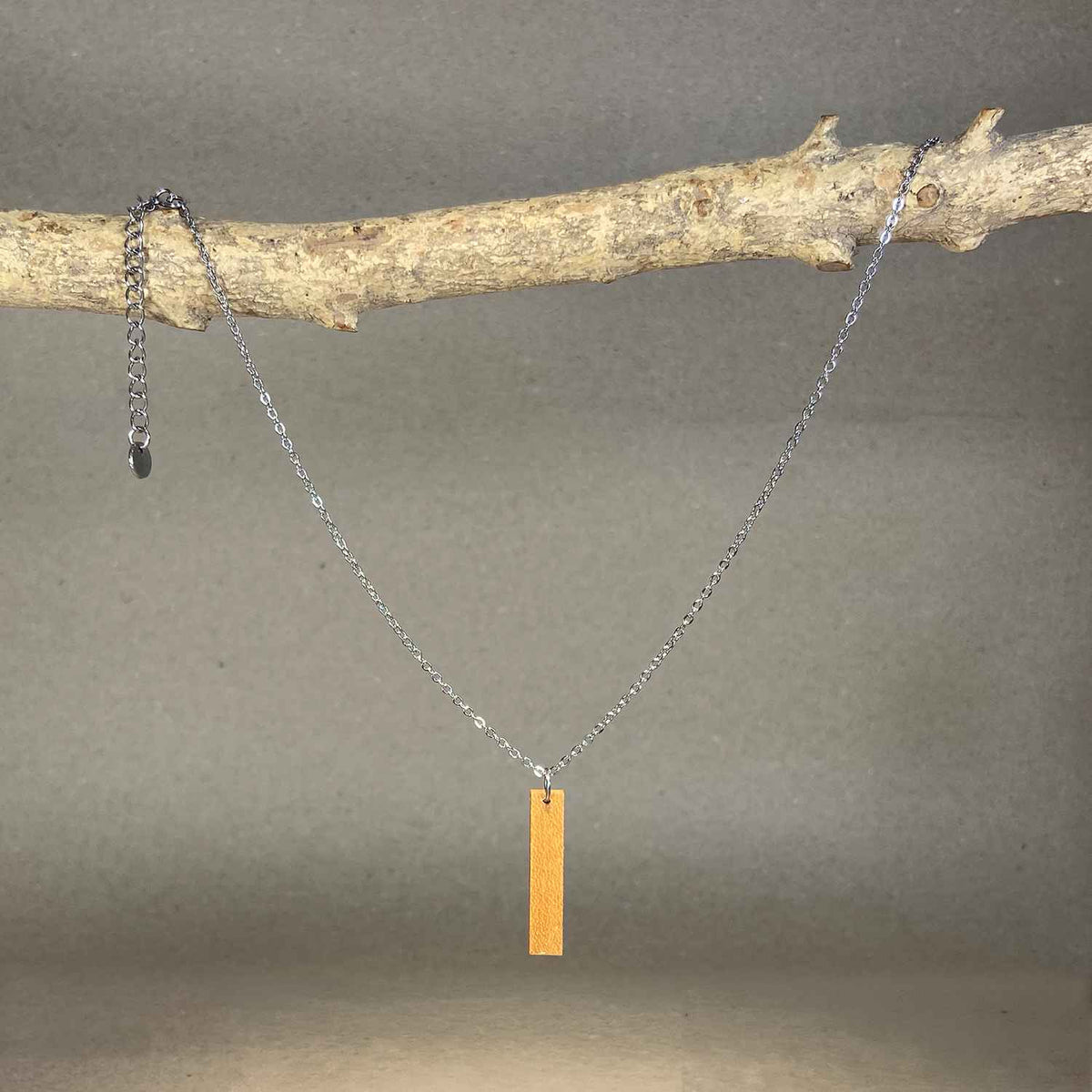 collier barre femme en bois de merisier et acier argenté, suspendu à une branche, fabrication artisanale française, racines artisanat