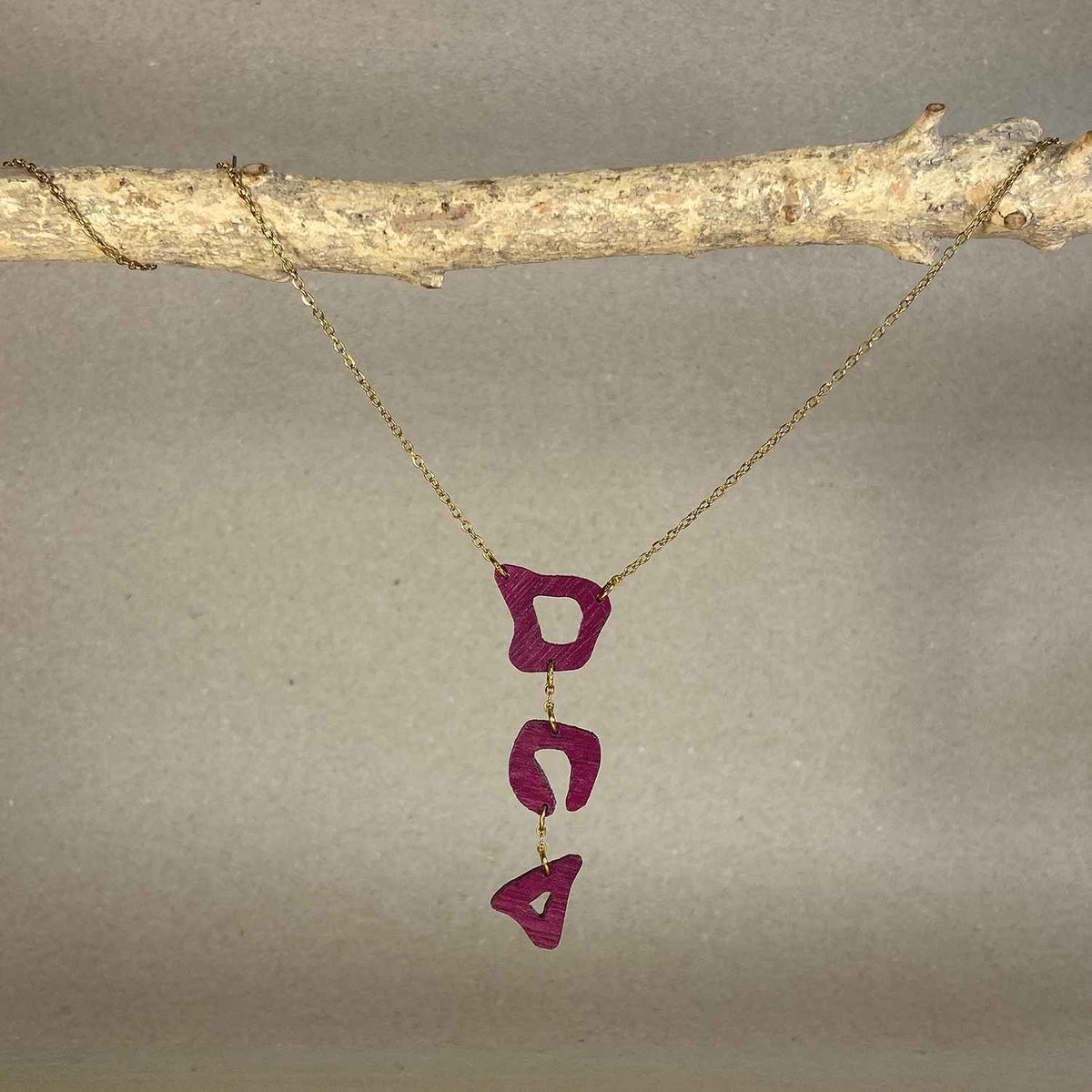 collier léopard femme en bois d'amarante et acier doré, suspendu à une branche, fabrication artisanale française, racines artisanat