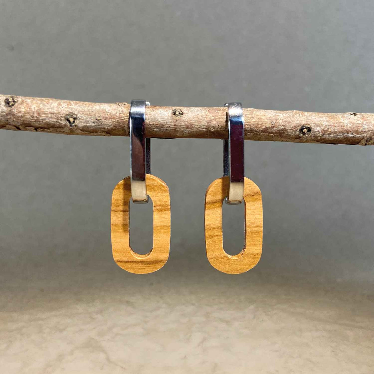 boucles d'oreilles créoles ovale femme en bois d'olivier et acier argenté, suspendu à une branche, fabrication artisanale française, racines artisanat