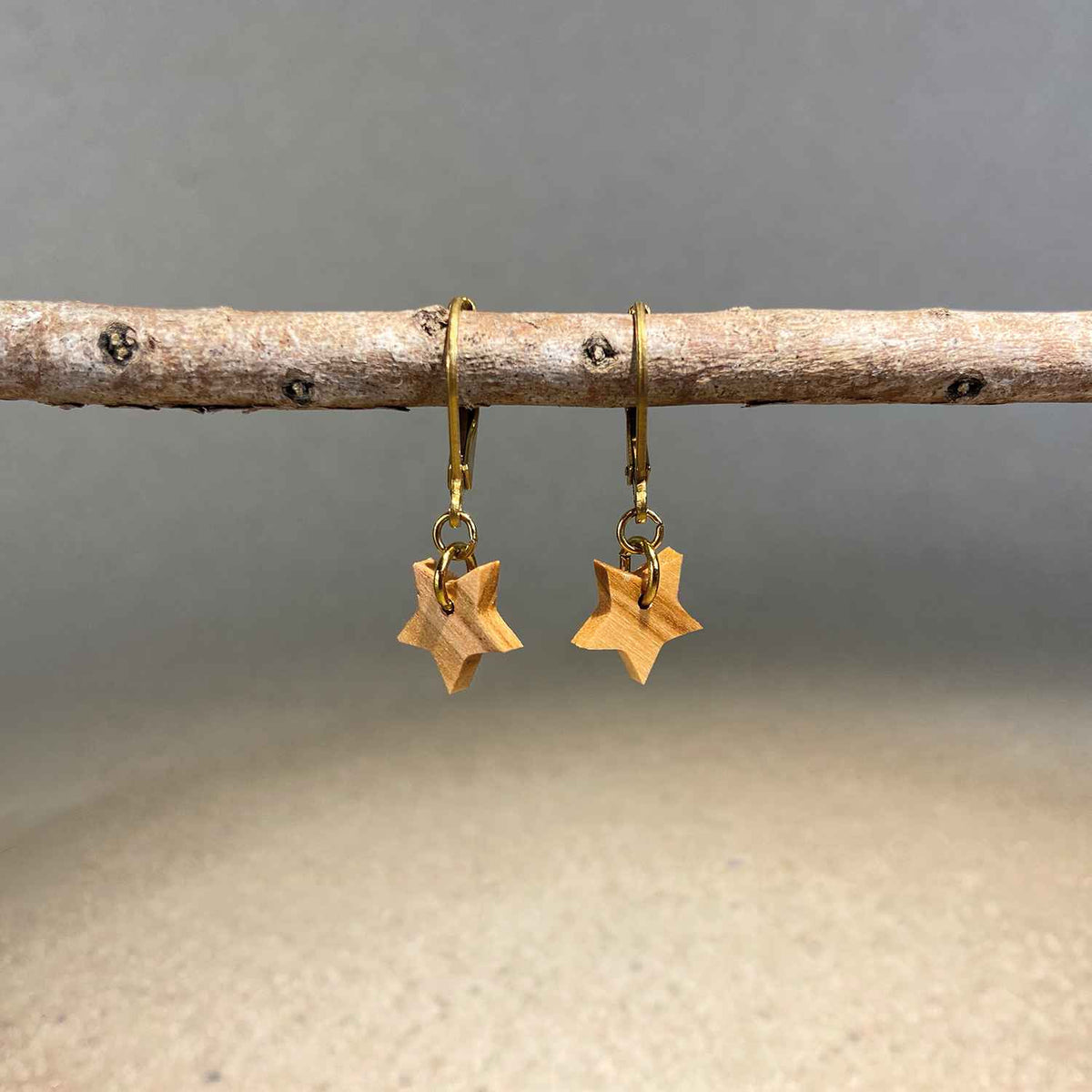 boucles d'oreilles dormeuses étoile femme en bois d'olivier et acier doré, suspendu à une branche, fabrication artisanale française, racines artisanat