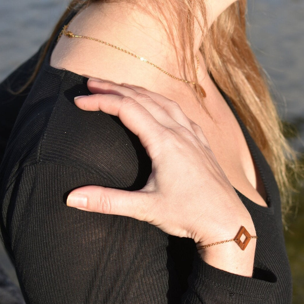 bracelet carré femme en bois de noyer et acier doré, porté à un poignet, fabrication artisanale française, racines artisanat