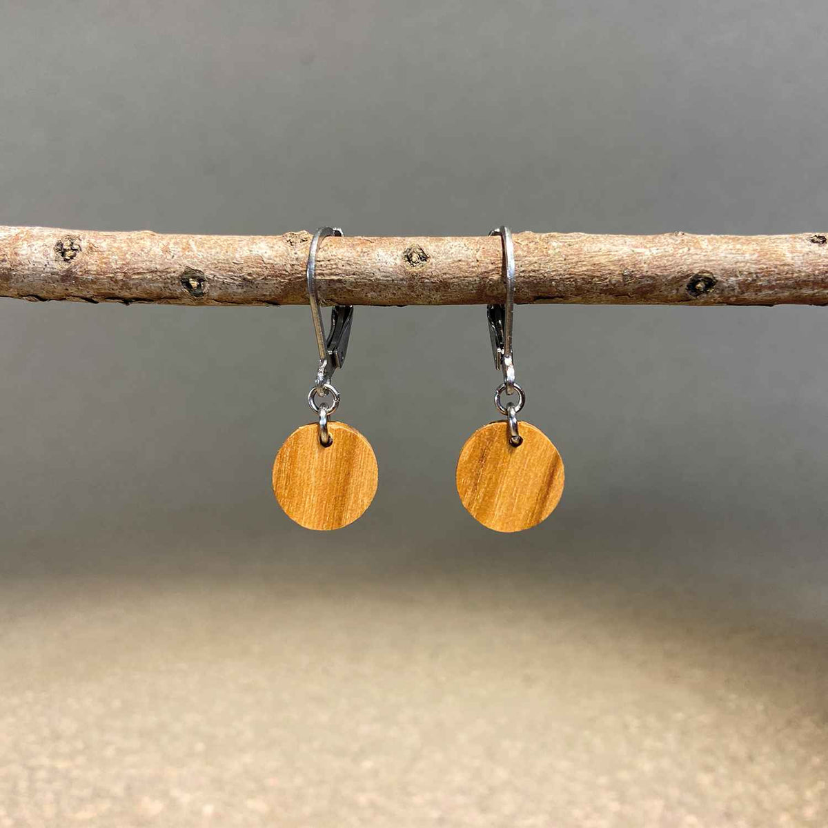 boucles d'oreilles rondes femme en bois d'olivier et acier argenté, suspendues à une branche, fabrication artisanale française, racines artisanat