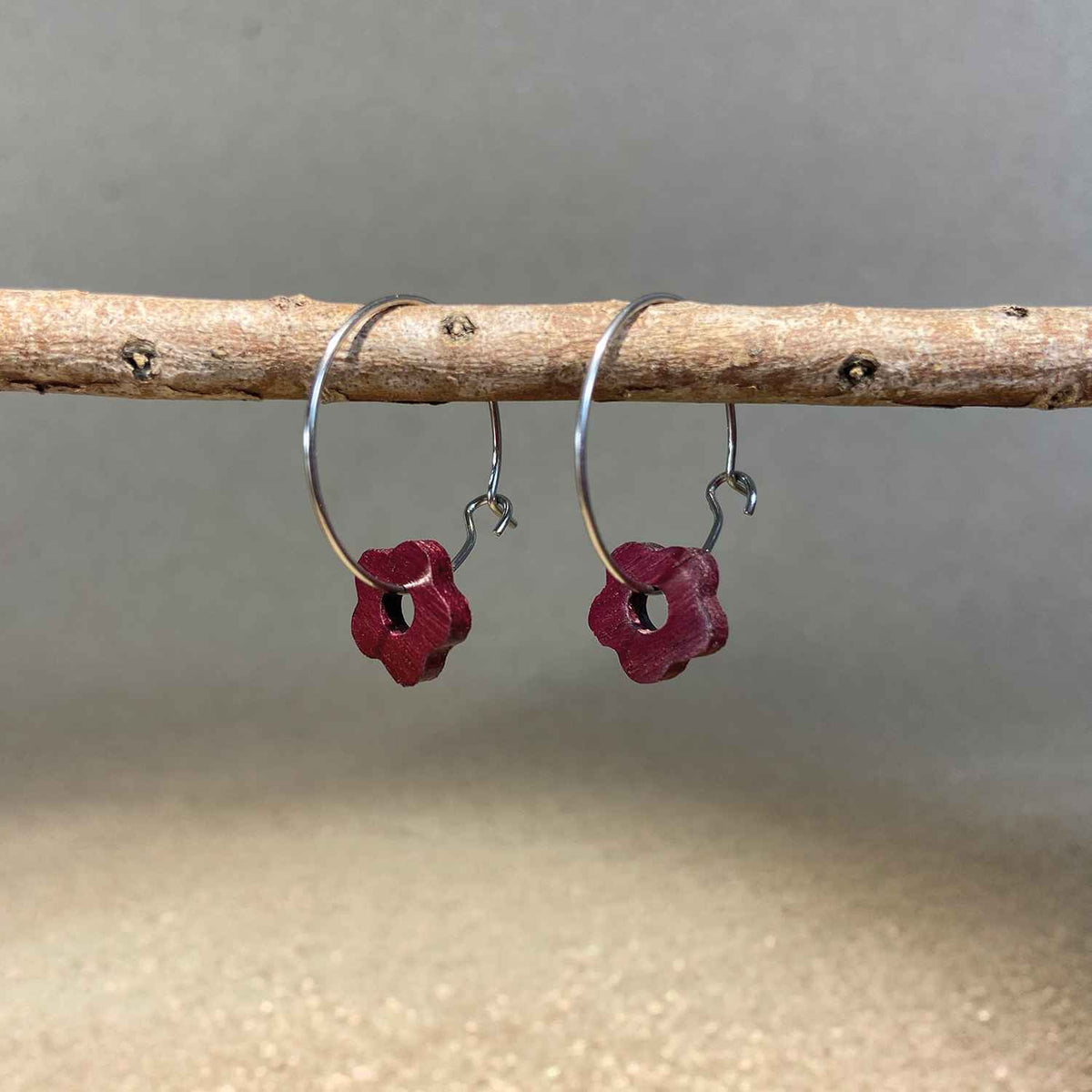 boucles d'oreilles créoles marguerite femme en bois d'amarante et acier argenté, suspendues à une branche, fabrication artisanale française, racines artisanat