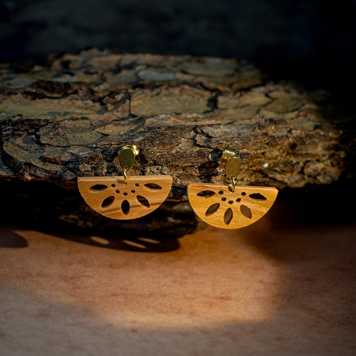 boucles d'oreilles dormeuses demi-rond femme en bois de rose et acier doré, accrochées à une branche, fabrication artisanale française, racines artisanat