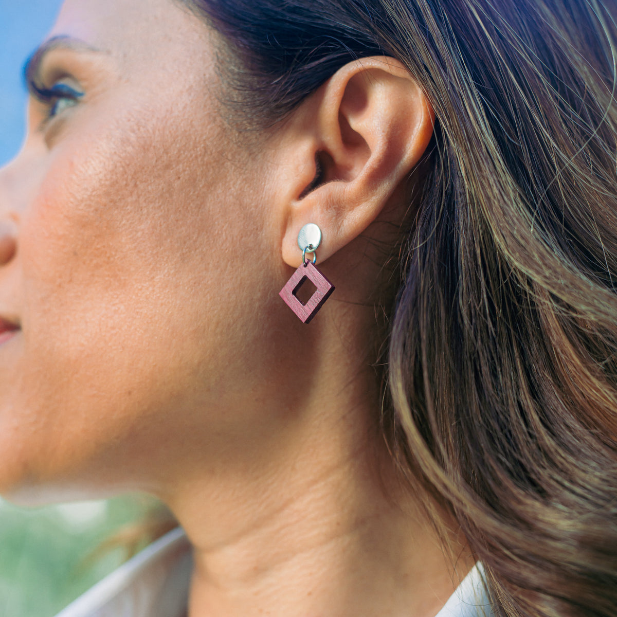 boucles d'oreilles clous carrés femme en bois de noyer et acier argenté, portées à une oreille, fabrication artisanale française, racines artisanat