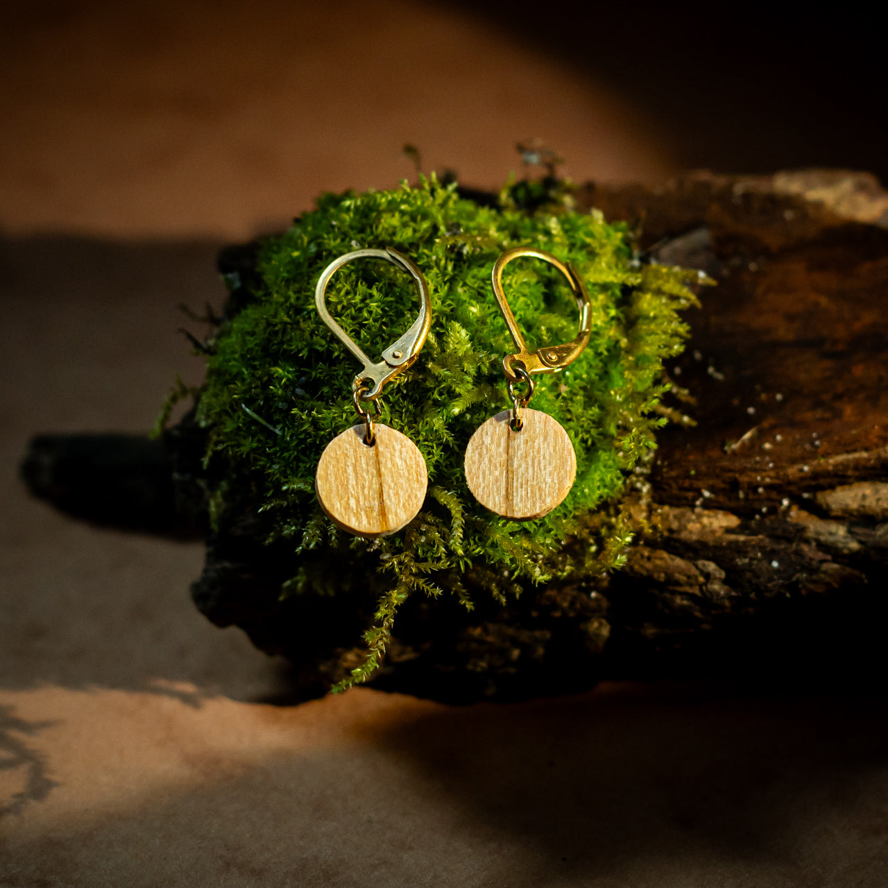 boucles d'oreilles rondes femme en bois de merisier et acier argenté, posées sur une branche, fabrication artisanale française, racines artisanat