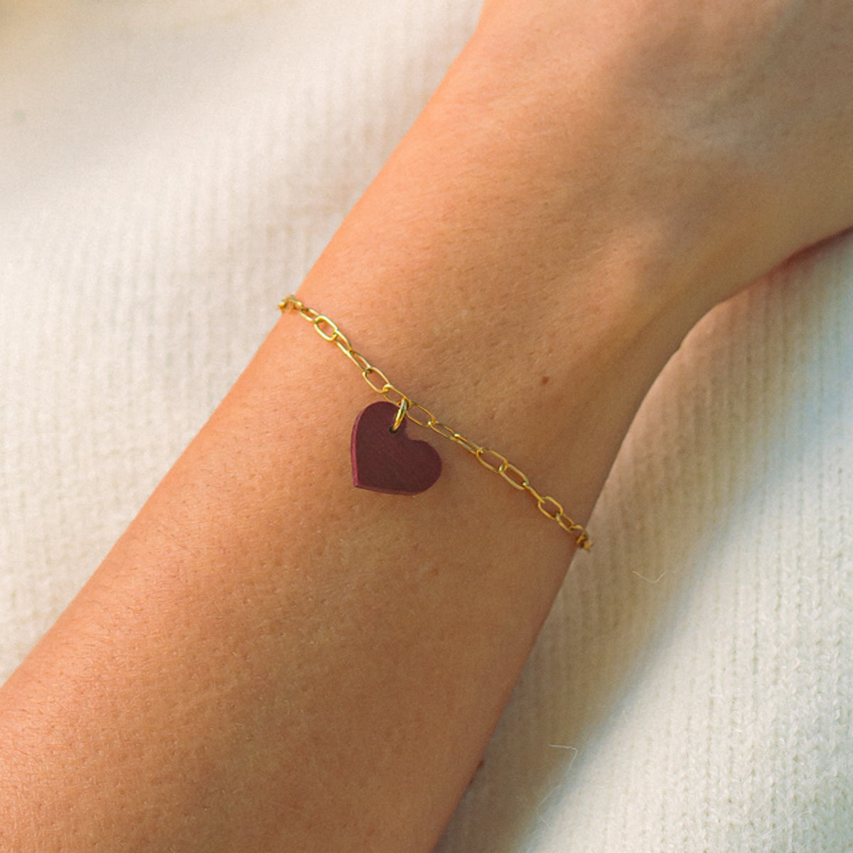 bracelet coeur femme en bois d'amarante et acier doré, porté à un poignet, fabrication artisanale française, racines artisanat