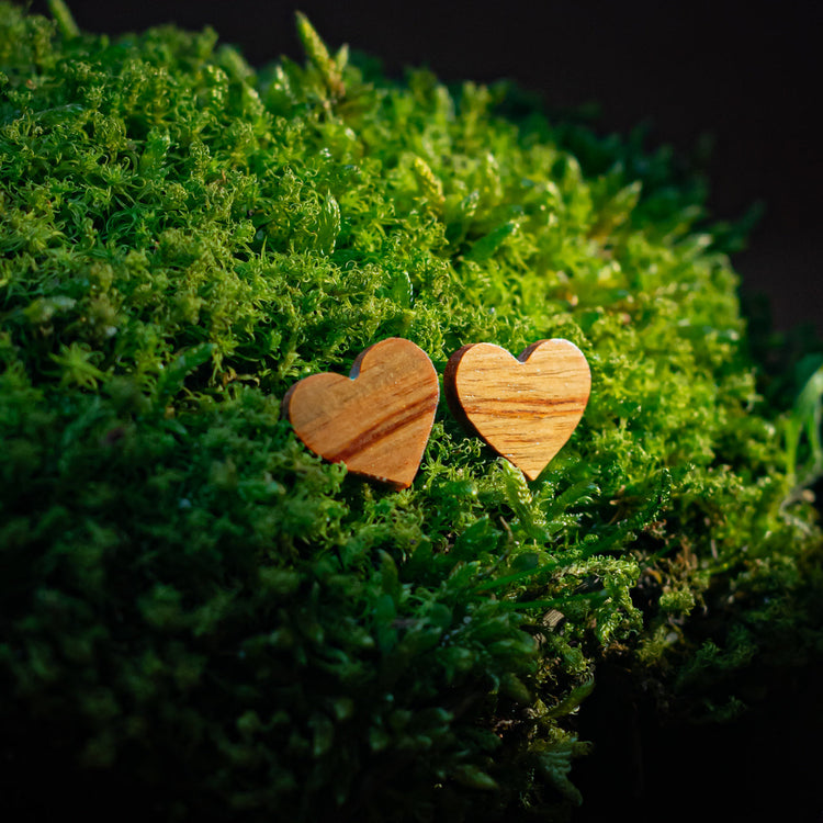 puces d'oreilles coeur femme en bois de rose, posées sur de la mousse, fabrication artisanale française, racines artisanat