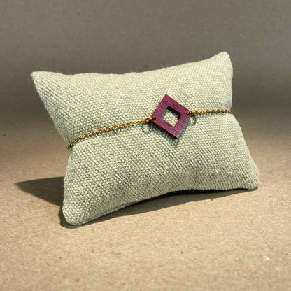 bracelet carré femme en bois d'amarante et acier doré, accroché à un coussin, fabrication artisanale française, racines artisanat