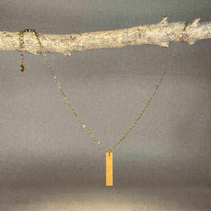 collier pendentif barre femme en bois de merisier et acier doré, suspendu à une branche, fabrication artisanale française, racines artisanat