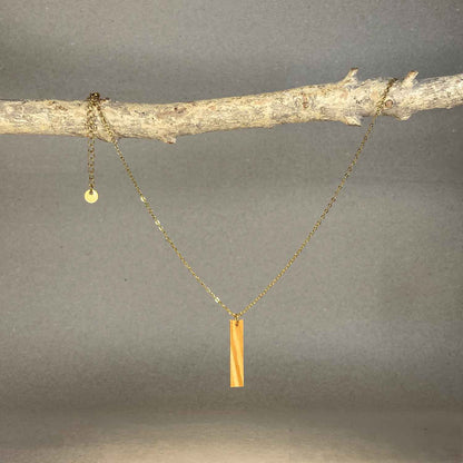 collier pendentif barre femme en bois d'olivier et acier doré, suspendu à une branche, fabrication artisanale française, racines artisanat