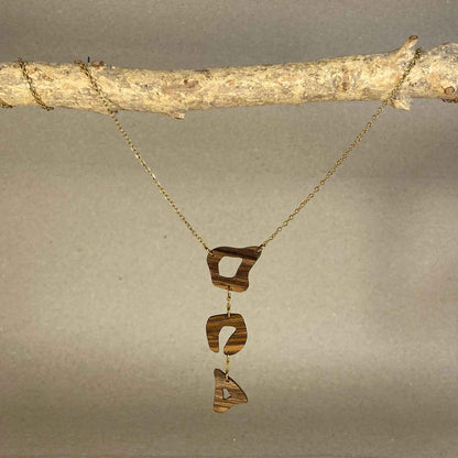 collier léopard femme en bois de noyer et acier doré, suspendu à une branche, fabrication artisanale française, racines artisanat