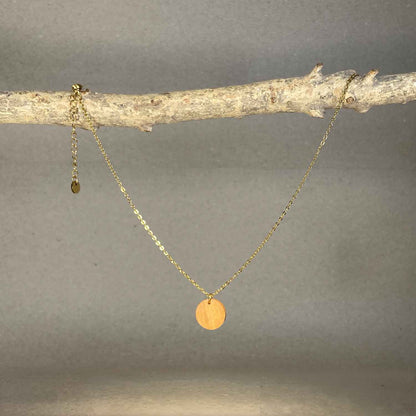 collier pendentif rond femme en bois de merisier et acier doré, suspendu à une branche, fabrication artisanale française, racines artisanat