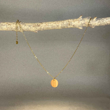 collier pendentif rond femme en bois d'olivier et acier doré, suspendu à une branche, fabrication artisanale française, racines artisanat