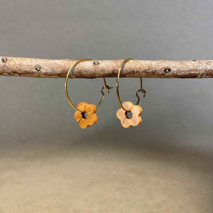 boucles d'oreilles créoles marguerite femme en bois d'olivier et acier doré, suspendues à une branche, fabrication artisanale française, racines artisanat