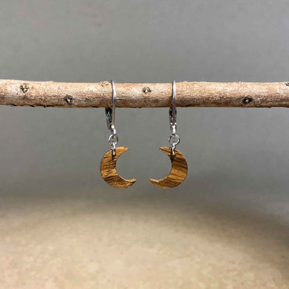 boucles d'oreilles demi-lune femme en bois de noyer et acier argenté, suspendues à une branche, fabrication artisanale française, racines artisanat