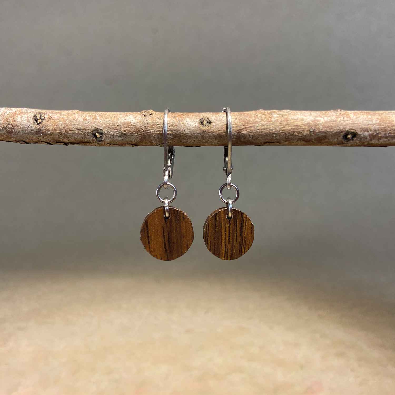 boucles d'oreilles rondes femme en bois de noyer et acier argenté, suspendues à une branche, fabrication artisanale française, racines artisanat