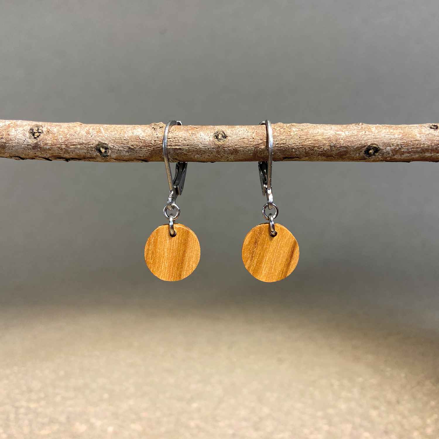 boucles d'oreilles rondes femme en bois d'olivier et acier argenté, suspendues à une branche, fabrication artisanale française, racines artisanat