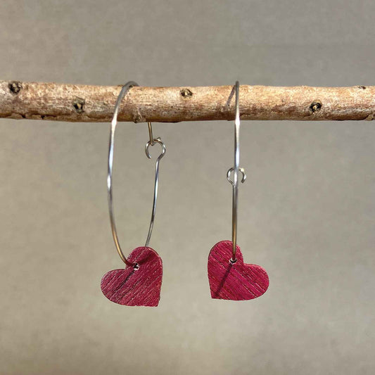 boucles d'oreilles créoles coeur femme en bois d'amarante et acier argenté, suspendues à une branche, fabrication artisanale française, racines artisanat