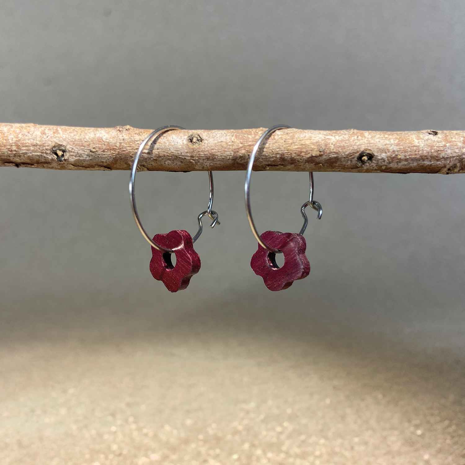 boucles d'oreilles créoles marguerite femme en bois d'amarante et acier argenté, suspendues à une branche, fabrication artisanale française, racines artisanat