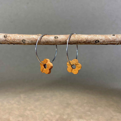 boucles d'oreilles créoles marguerite femme en bois de merisier et acier argenté, suspendues à une branche, fabrication artisanale française, racines artisanat