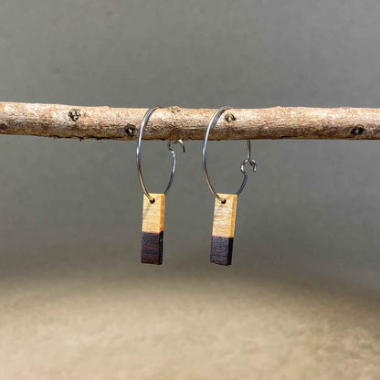boucles d'oreilles créoles petite barre femme en aubier du bois de violette et acier argenté, suspendues à une branche, fabrication artisanale française, racines artisanat